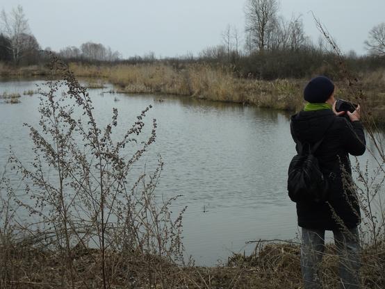 A flooded area in Kyiv Oblast and a colleague taking a picture