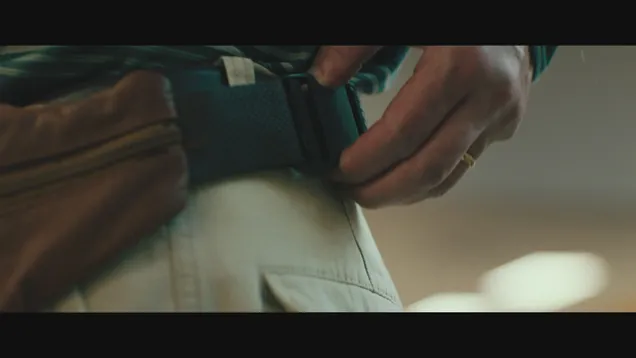 Fanny pack on an Asian man (close up of the fanny pack) wearing slacks and a green shirt, from the movie "Everything Everywhere At Once"