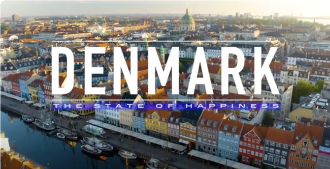 Screenshot from start of 'Denmark, The State of Happiness' with the title overlaying an aerial view of a town (Copenhagen?)