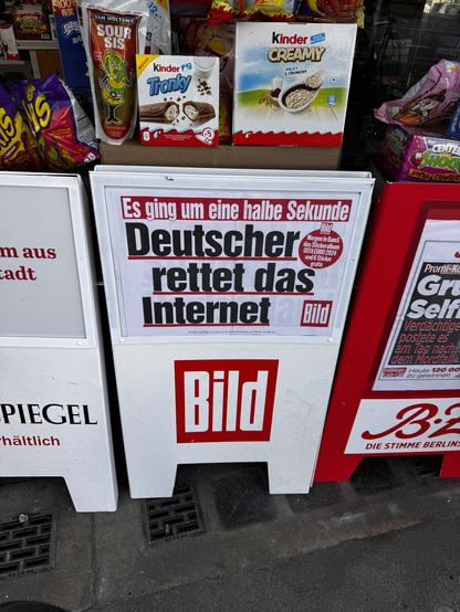 Ein Zeitungsstand mit verschiedenen Snacks und der Schlagzeile "Deutscher rettet das Internet" auf einer "Bild"-Zeitung.