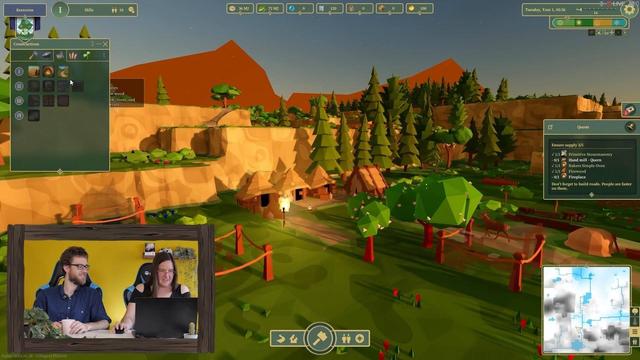 Screenshot of a game with low poly houses and trees, a video stream of two people playing