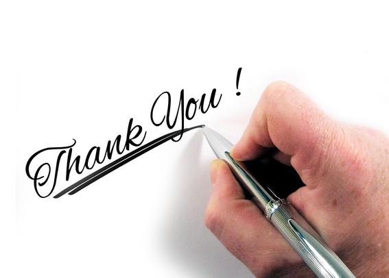 Hand holding a pen, writing "Thank you!" in fancy calligraphy. Represents gratitude to my followers.