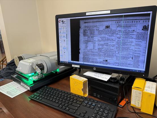 A computer attached to an automated microfiche reader. You click buttons, and the roll advances, pans, and zooms as needed. (You can also move it manually.)