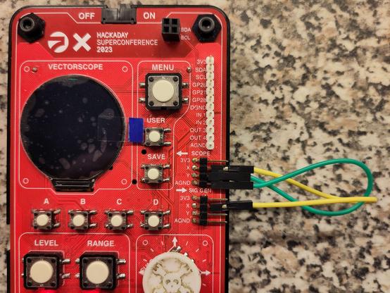 photo of red vectorscope badge with two wires connecting two ports of the badge.