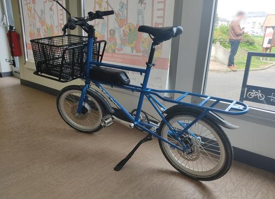 Un vélo "petit porteur" bleu.

###

A blue "petit porteur" bicycle.