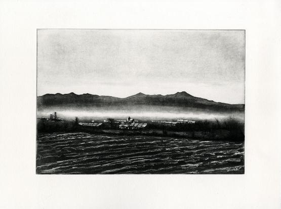 Black and white etching looking a cross a plowed field to the roof tops of Newtongrange. Behind the Pentland Hills rise above mist in the North Esk valley.