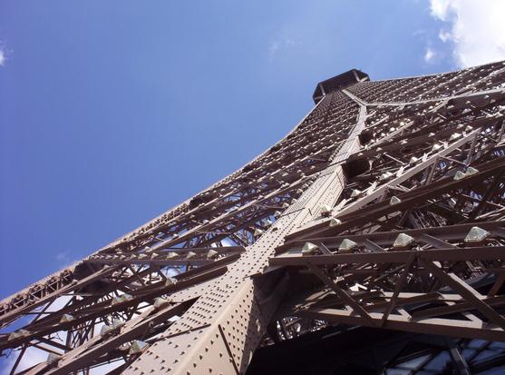 A close-up of the Eiffel Tower looking up
