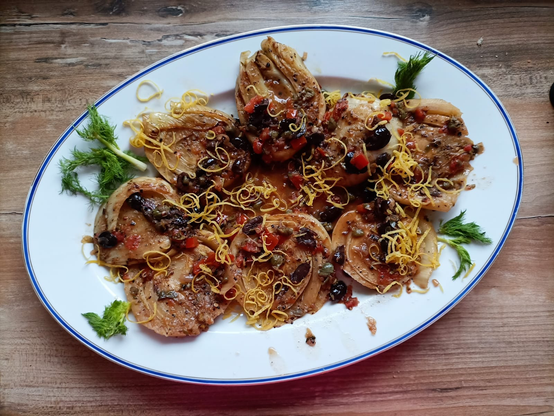 Die gegarten Fenchelscheiben auf einer Servierplatte  mit den andere Zutaten.