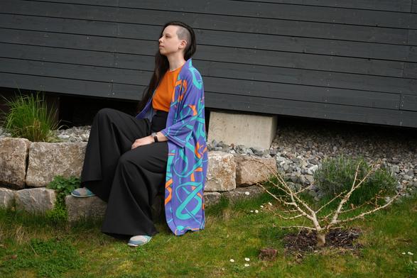 bleeptrack sitting in front of her tiny house on some stones