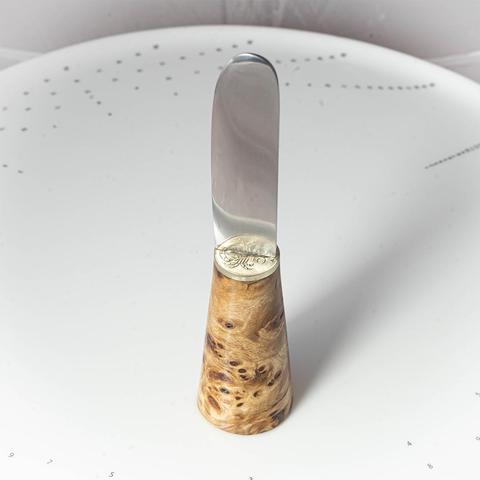 un couteau à tartiner dont la base est évasée pour pouvoir tenir debout.
Le manche est en peuplier stabilisé, la mitre en pièce de monaie