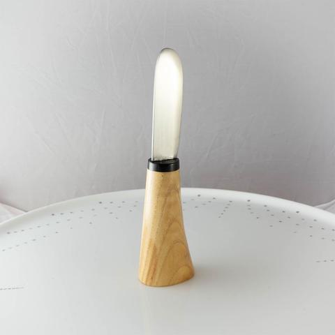 un couteau à tartiner dont la base est évasée pour pouvoir tenir debout.
Le manche est en platane, la mitre en ébène