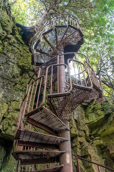 A spiral staircase leads hikers down a cliff in the woods in Spirit Rock Conservation Area near Wiarton, Ontario.