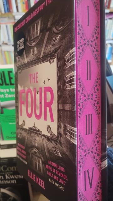 Side-on view of the cover of Ellie Keel's novel The Four, the title in a piece of sky, boxed in on all four sides (of course!) by identiacal looming walls of a grand country house.THe edges of the pages are "spredges" (sprayed edges), coloured a dark purple, with interlocking pattens, between which is a descending set of Roman numerals from 1 to 4