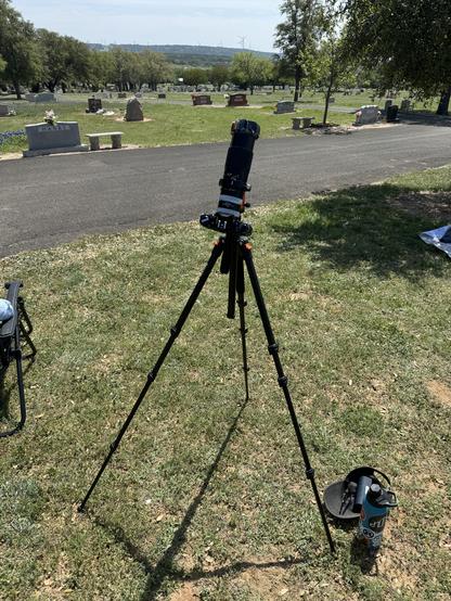 A film camera on tripod with a long zoom lens and solar filter set up to capture the April 2024 total solar eclipse.