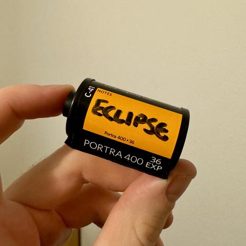 A close up shot of a roll of 36 exposure Porta 400 35mm film with the word “ECLIPSE” sharpy’d on its side.