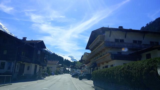 Ortsdurchfahrt durch Lanersbach, links und rechts Häuser, im Hintergrund der Gletscher