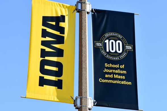 Street banners commemorating the 100th anniversary of the school of journalism at University of Iowa