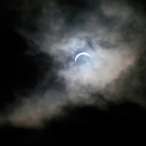 Picture of the eclipse near totality. About 90% covered, through the clouds.