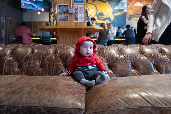 Toddler in red hoody on big couch