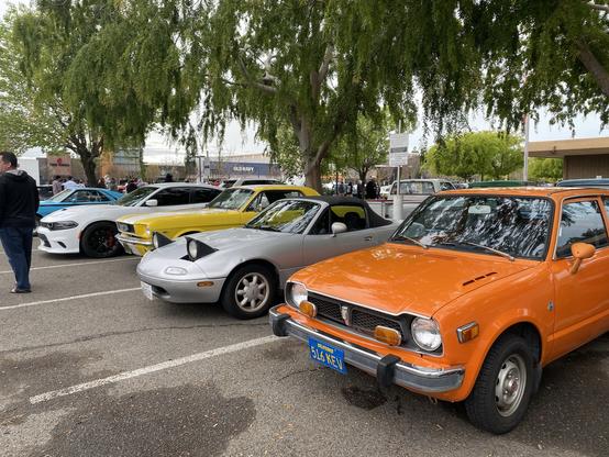 Orange Honda Civic next to silver Miata at car show