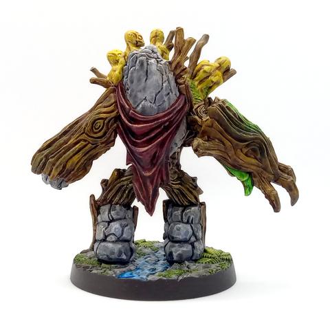 The view of the back side of the miniature shows that the tree's back is also a slab of stone and it has a cape draped around it.