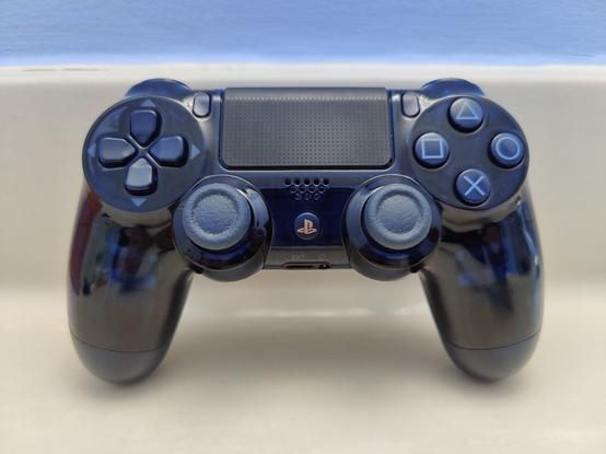 The Dual Shock 4 500 million edition controller that was released as a celebration of the PlayStation series selling in total over 500 million units across all generations at the time. Like the post described, the shell is a rather opaque dark blue that isn't so opaque that the internals of the device are somewhat visible. The buttons are also blue and the PS button shown here has gold lettering.