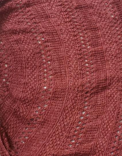 Close up of pink Mingling Daisies Shawl, with a three band repeat of broken rib, lattice and daisy stitches, four repeats done