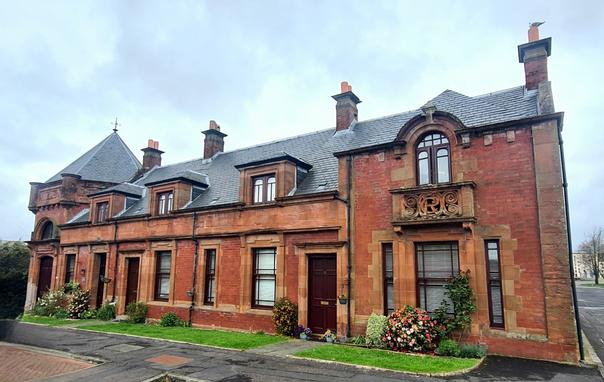 A low two-storey red brick former railway station.