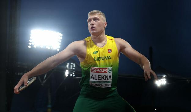 Discus thrower Mykolas Alekna wearing the yellow and gold colors of Lithuania in the wind up phase of a discus throw