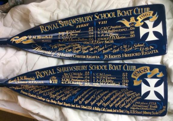 The ends of two oars that have been hand-lettered with paint and gold leaf for the Royal Shrewsbury School Boat Club. There are various elements to this with the focus being the 1967 and 1968 first eight rowers on the team for each year.