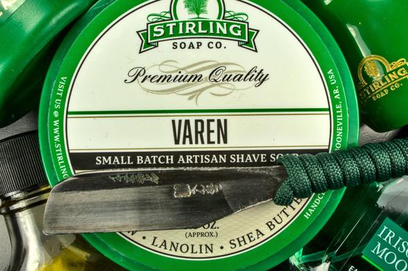A closeup on a sacrificial tub of Stirling Varen soap and a Henkotsu Kamisori with green fernishings presents itself on the tub.