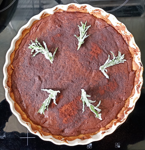 Die fertig gebackene und mit kristallisierten Rosmarinzweigen dekoriert Schoko-Tarte in der Tarte-Form von oben.