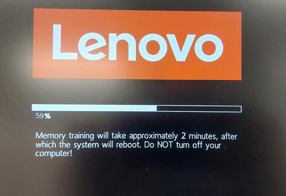 Photo of a Lenovo ThinkPad T14s notebook screen during a BIOS update 

It has a large red Lenovo logo
A status bar at 59%
Underneath the text as follows:
Memory training will take approximately 2 minutes, after
which the system will reboot. Do NOT turn off your
computer!