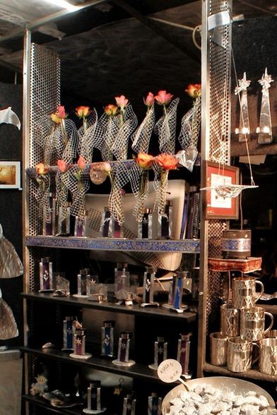 Ein Regal in meiner Weihnachtsmarktbude, gefüllt mit Rosenvasen und Teelichtleuchtern.

A shelf in my Christmas market stall, filled with rose vases and tea light candlesticks.
