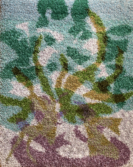 Vertical thick-pile wallhanging (rug) depicting an abstracted flames and smoke clouds in solid colour shapes. The background colours are pale teal and warm grey overlaid with purple shapes on the bottom of the composition and yellow-green arcing flames reaching for the top. Dark green shapes are formed by overlapping green and teal shapes.