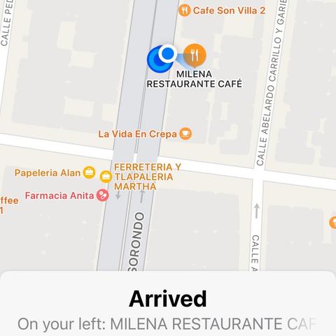 A map interface showing the arrival at a location, "MILENA RESTAURANTE CAFÉ," with various other nearby businesses like "Cafe Son Villa 2," "La Vida En Crepa," "Papeleria Alan