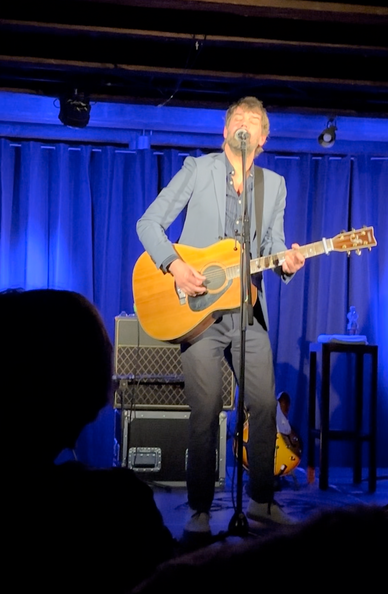 Niels Frevert mit Gitarre auf einer Bühne