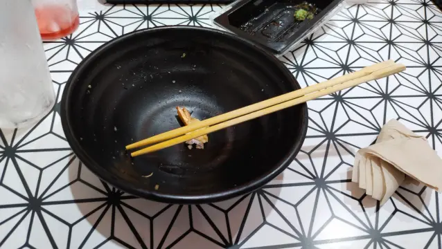 Same bowl finished with shrimp tail leftover (from another meal) and chopsticks