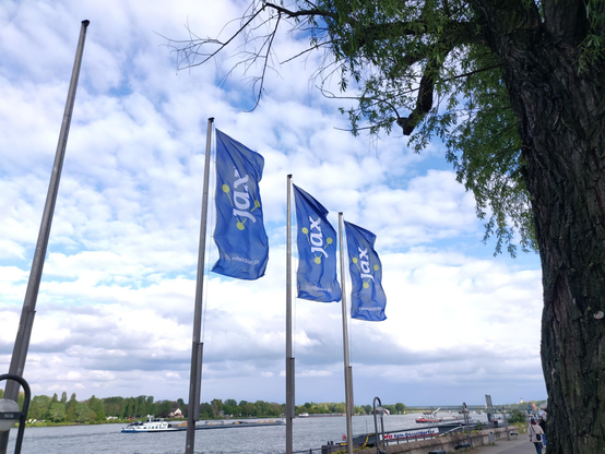 Fahnen der JAX vor der Kongresshalle am Rhein.