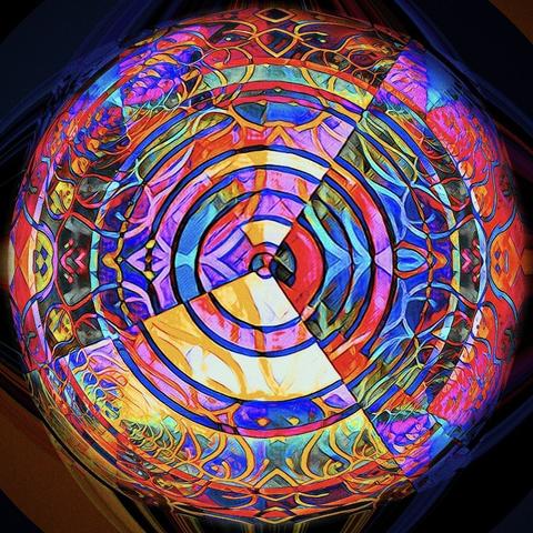 Kaleidoskopartiges, mandalaähliches, abstraktes rundes Farbgebilde in Rosa-, Blau-, Lila- und Gelbtönen.