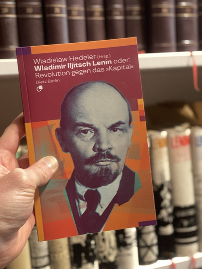 Buchcovder der Hedeler-Miniatur in die Kamera gehalten, Portrait von Lenin