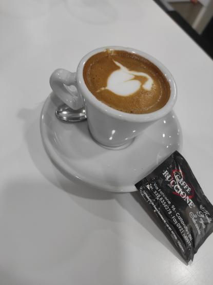 Tazzina di caffè espresso con bustina di zucchero