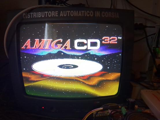 The colorful Amiga CD32 startup screen, with Amiga CD32 written on top, a compact disc in the center, and colored waves zooming in on top and bottom of it.