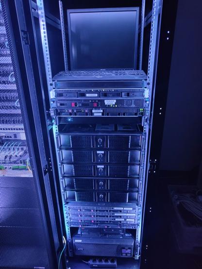 Photo of an opened server rack showing the different servers on the inside. 
The rack is lit up in a purple blueish light.