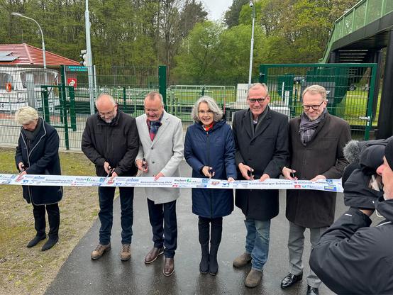 Gruppenbild beim feierlichen Durchschneiden eines bedruckten Bandes. V.l.n.r. Karina Dörk, Landrätin LK Uckermark, Daniel Kurth, Landrat LK Barnim, Detlef Tabbert, Bürgermeister der Stadt Templin, Susanne Henckel, Staatssekretärin BMDV, Franz-Christoph Michel, Vorsitzender Stadtverordnetenversammlung Stadt Templin, Eric Oehlmann, Leiter der GDWS.