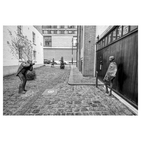 Black and white photo showing sculptures of Terence Donovan photographing Twiggy in Bourdon Place, London.