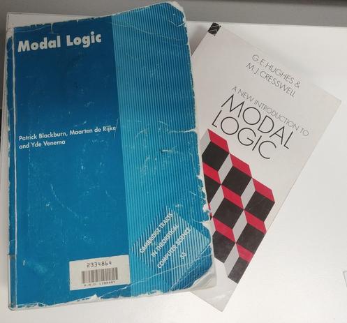 The textbook 'Modal Logic' by Patrick Blackburn, Maarten de Rijke, and Yde Venema, on top of another textbook, 'A New Introduction to Modal Logic' by G.E. Hughes and M. J. Cresswell