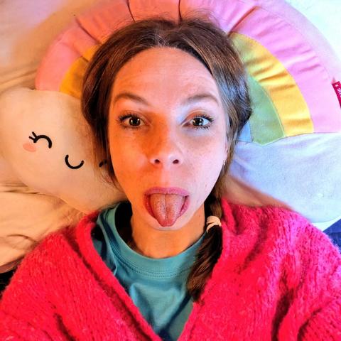Me recreating the pic in the quoted tweet from my hospital bed, lying on my back, this time on a rainbow pillow, sticking my tongue out