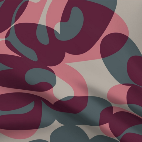 Close-up of a section of fabric with a print in overlapping grey and purple lozenge and free-hand bulbous shapes. The design is titled Fire Blot - Red.