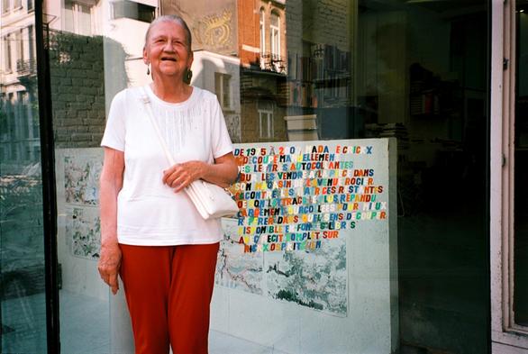 Chrystel Crickx tout sourire devant la vitrine de Spec, en partie lettrées avec des lettres du stock, à l'été 2023.